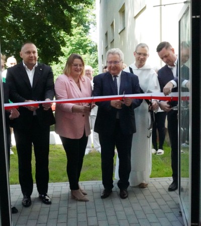 zdjęcie przedstawia przecięcie wstęgi przez gości honorowych